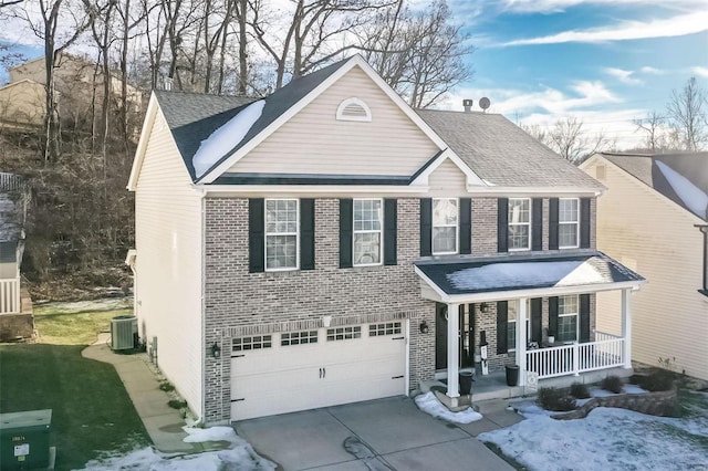 view of front of property with a porch, a garage, central AC unit, and a front lawn