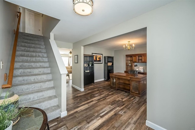 stairs featuring ceiling fan with notable chandelier and hardwood / wood-style floors