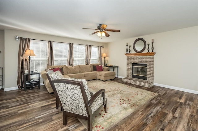 living room featuring ceiling fan, dark hardwood / wood-style flooring, and a brick fireplace