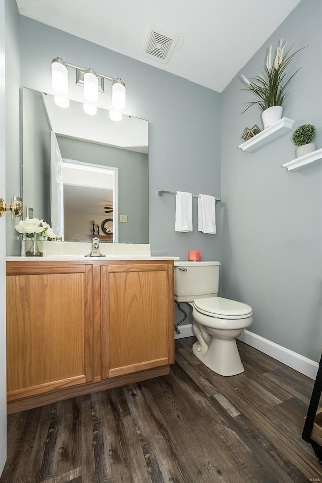 bathroom with vanity, wood-type flooring, and toilet