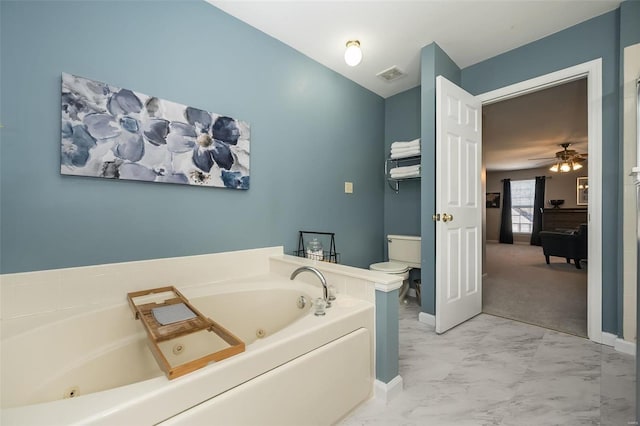 bathroom featuring a tub, ceiling fan, and toilet