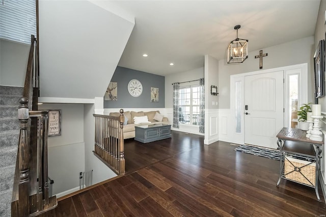 entrance foyer featuring dark wood-type flooring and a notable chandelier