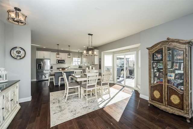 dining room with dark hardwood / wood-style flooring and a notable chandelier