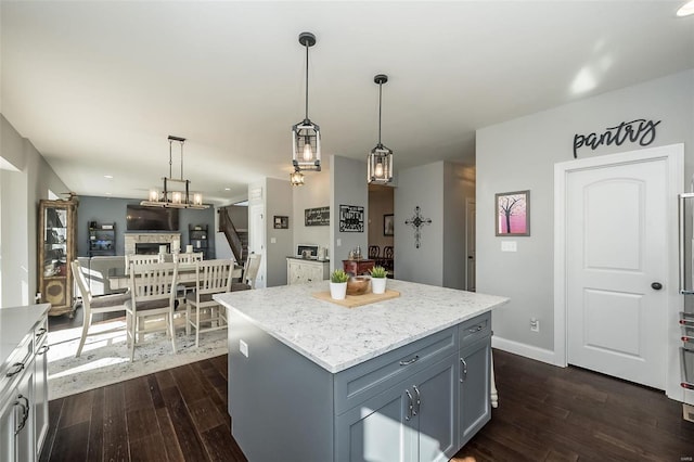 kitchen featuring pendant lighting, a fireplace, dark hardwood / wood-style floors, and a kitchen island