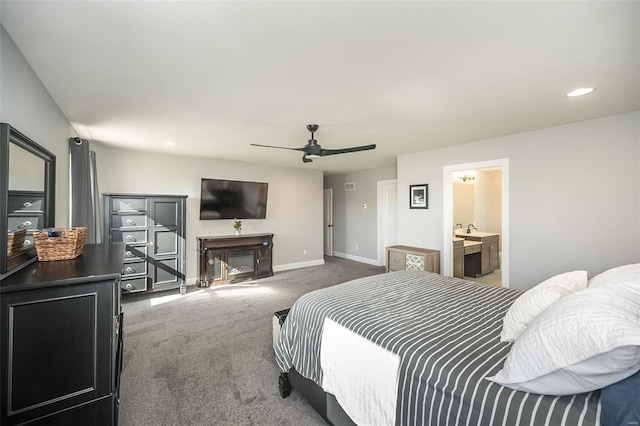 carpeted bedroom featuring ceiling fan, ensuite bathroom, and sink