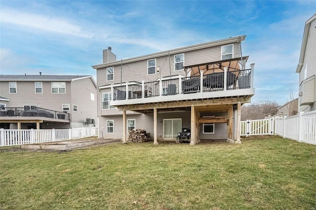 back of property featuring a wooden deck and a yard