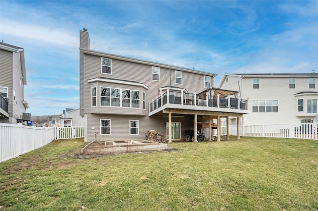 back of house featuring a wooden deck and a yard