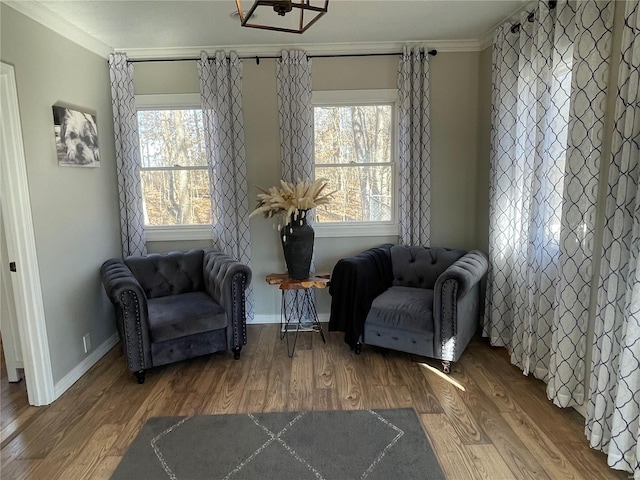 sitting room with wood-type flooring, plenty of natural light, and ornamental molding