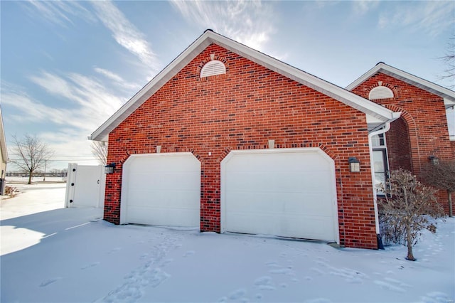 snow covered property featuring a garage