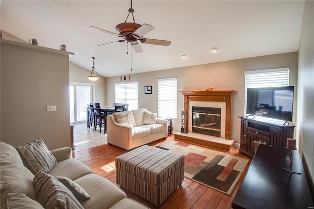 living room featuring vaulted ceiling, ceiling fan, and wood-type flooring