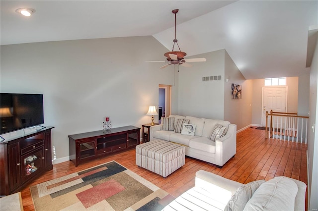 living room with ceiling fan, vaulted ceiling, and light hardwood / wood-style floors