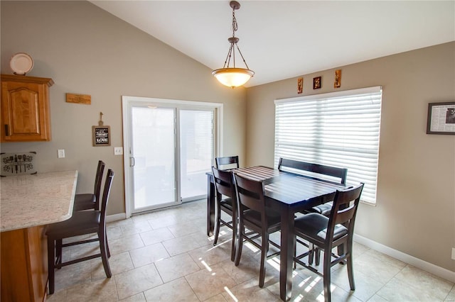 tiled dining room with vaulted ceiling and a wealth of natural light