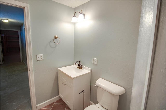 bathroom with toilet, a textured ceiling, tile patterned floors, and vanity