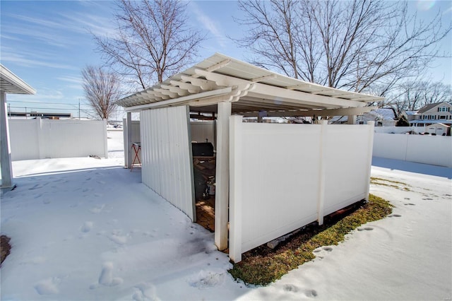 snow covered structure featuring a carport