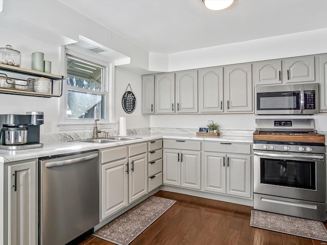 kitchen with gray cabinets, sink, appliances with stainless steel finishes, and dark hardwood / wood-style flooring