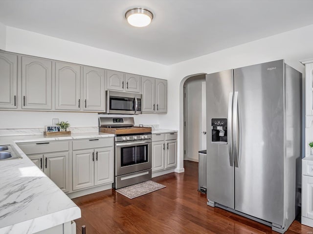 kitchen with stainless steel appliances, dark hardwood / wood-style flooring, and gray cabinets