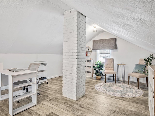 home office with lofted ceiling, wood-type flooring, and a textured ceiling