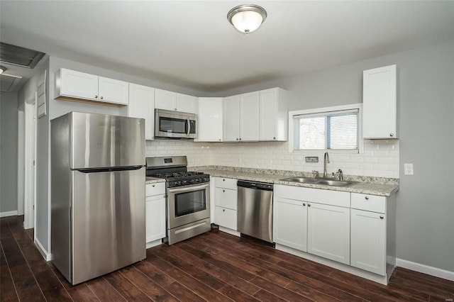 kitchen with dark wood-type flooring, appliances with stainless steel finishes, sink, and white cabinetry