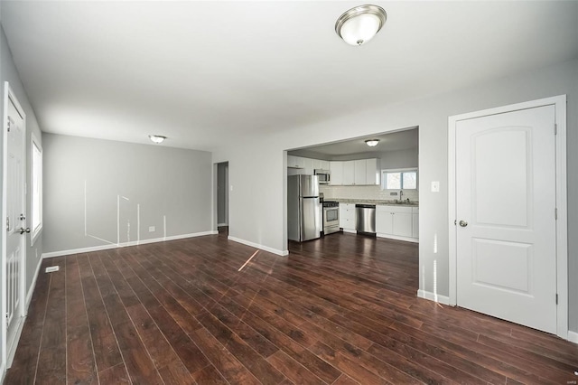 unfurnished living room featuring dark hardwood / wood-style flooring and sink