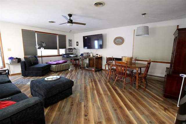 living room featuring dark hardwood / wood-style flooring, ceiling fan, and baseboard heating