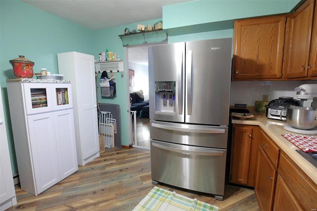 kitchen with light wood-type flooring and stainless steel refrigerator with ice dispenser