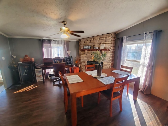 dining space with ceiling fan, vaulted ceiling, crown molding, dark wood-type flooring, and a textured ceiling