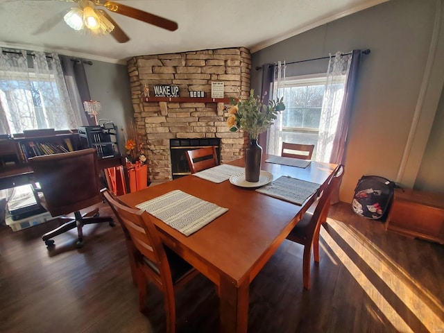 dining space featuring lofted ceiling, crown molding, a fireplace, and dark hardwood / wood-style floors