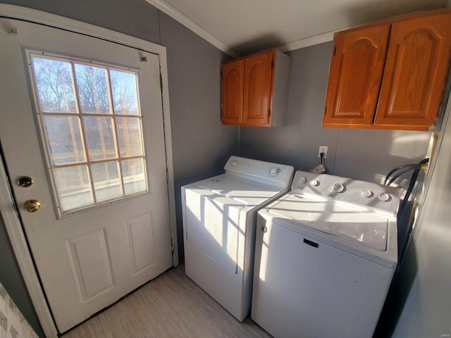 washroom with crown molding, separate washer and dryer, light hardwood / wood-style floors, and cabinets