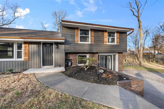 tri-level home featuring french doors and board and batten siding