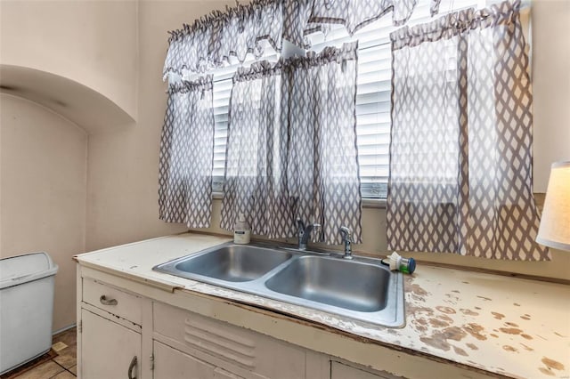 kitchen featuring white cabinetry and sink