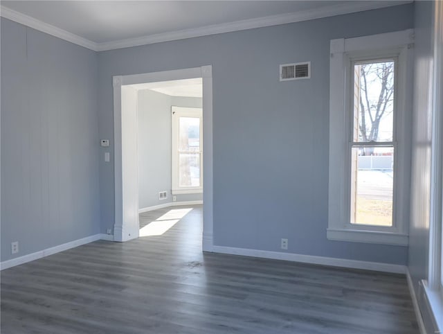 spare room featuring dark hardwood / wood-style floors and crown molding