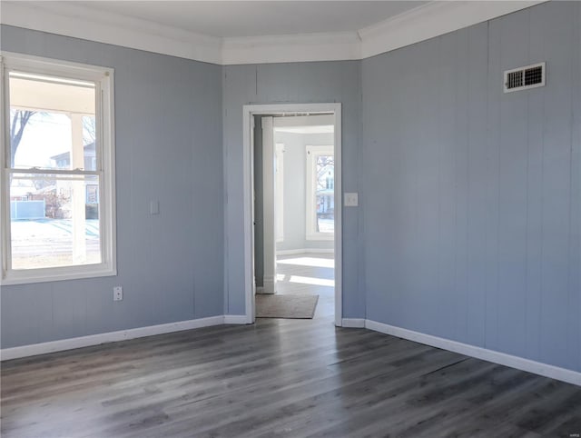 unfurnished room with dark hardwood / wood-style floors, ornamental molding, and a healthy amount of sunlight