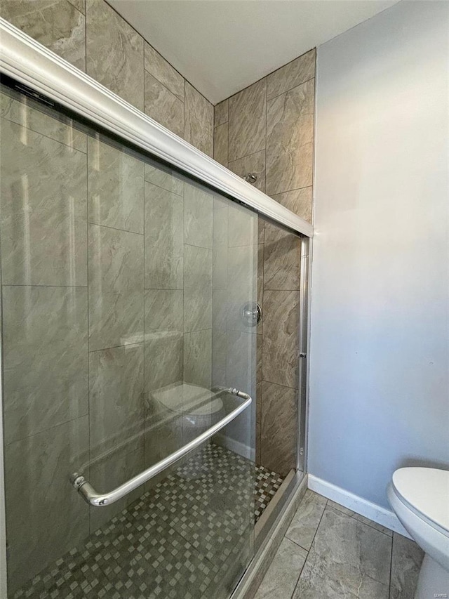 bathroom with toilet and a shower with door