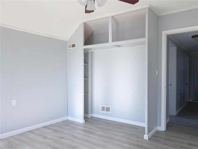 unfurnished bedroom with ceiling fan, a closet, ornamental molding, and light wood-type flooring