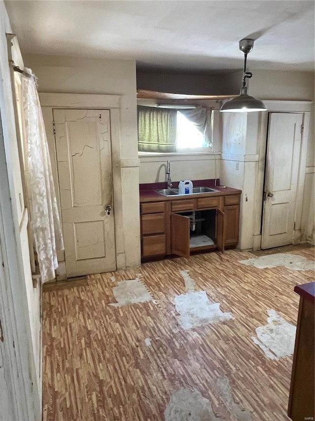 kitchen featuring pendant lighting, sink, and light hardwood / wood-style flooring