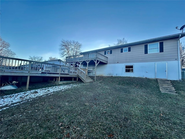 back of property with a wooden deck and a yard