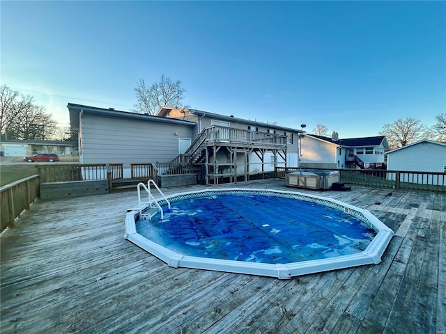 view of pool with a wooden deck and a hot tub