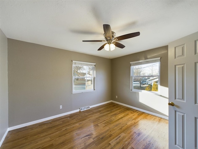 unfurnished room with hardwood / wood-style flooring, ceiling fan, and a textured ceiling