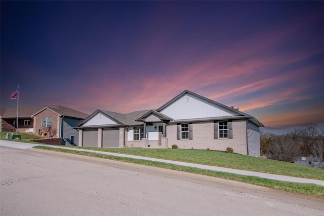 single story home featuring a garage and a yard