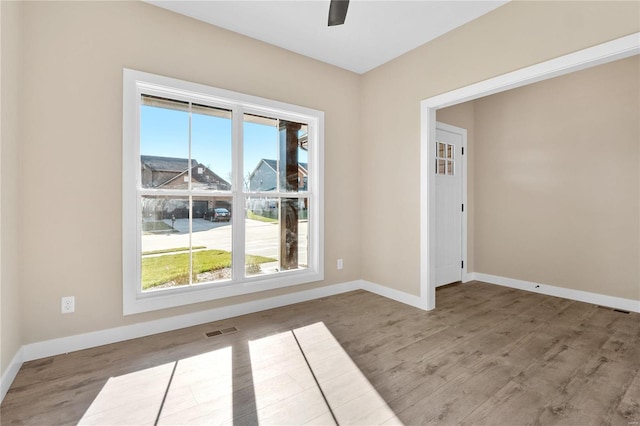 empty room with ceiling fan and hardwood / wood-style flooring