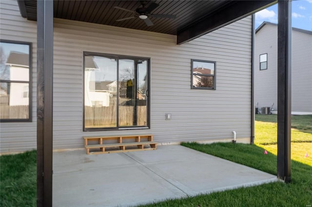 entrance to property with ceiling fan, a patio area, a lawn, and central air condition unit