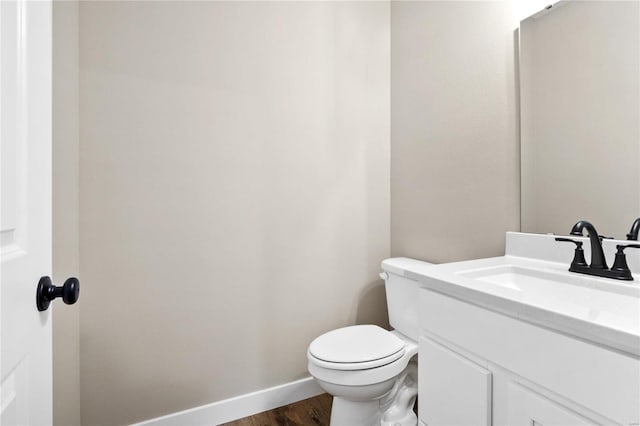 bathroom featuring toilet, hardwood / wood-style flooring, and vanity