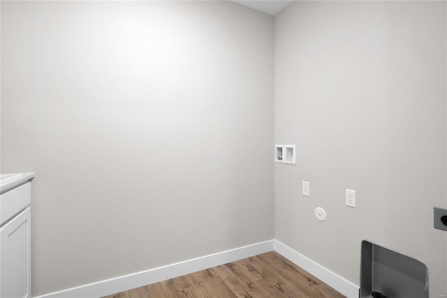 clothes washing area featuring washer hookup, hookup for an electric dryer, light hardwood / wood-style floors, and cabinets