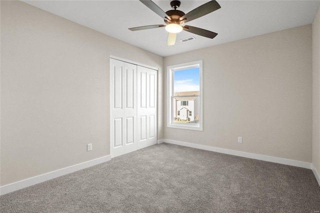 unfurnished bedroom with ceiling fan, a closet, and carpet