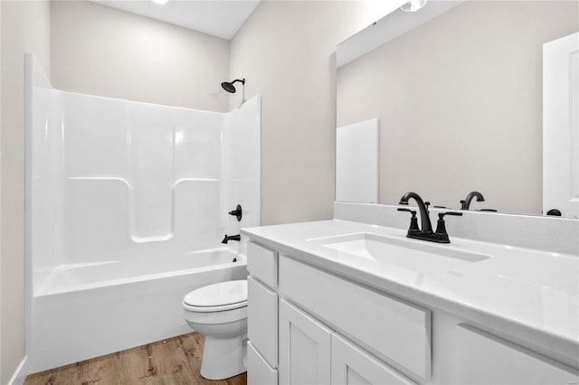 full bathroom with vanity, toilet, hardwood / wood-style flooring, and shower / washtub combination