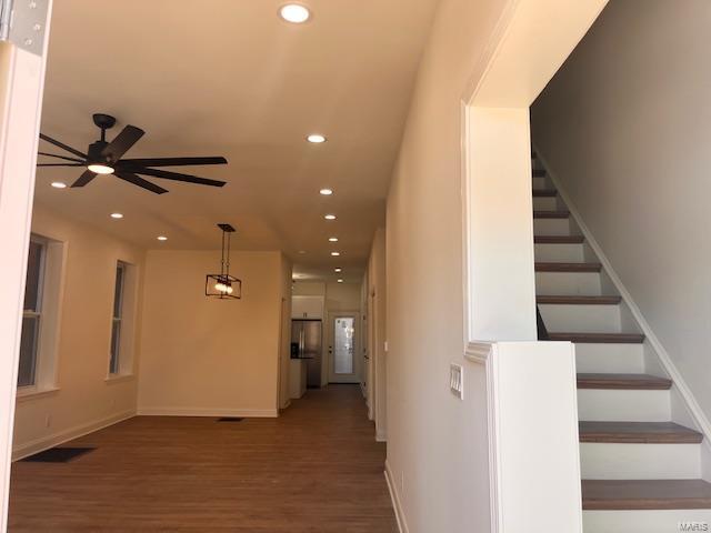 stairway featuring ceiling fan and wood-type flooring