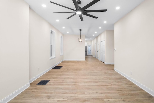 unfurnished living room featuring ceiling fan and light hardwood / wood-style flooring