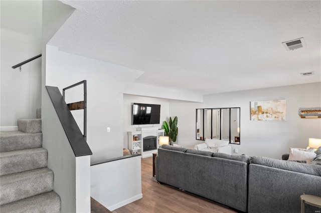 living room featuring a textured ceiling and light hardwood / wood-style floors