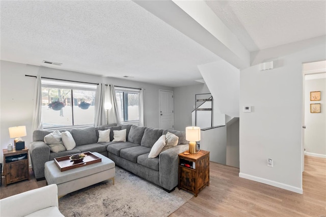 living room featuring a textured ceiling and light hardwood / wood-style flooring