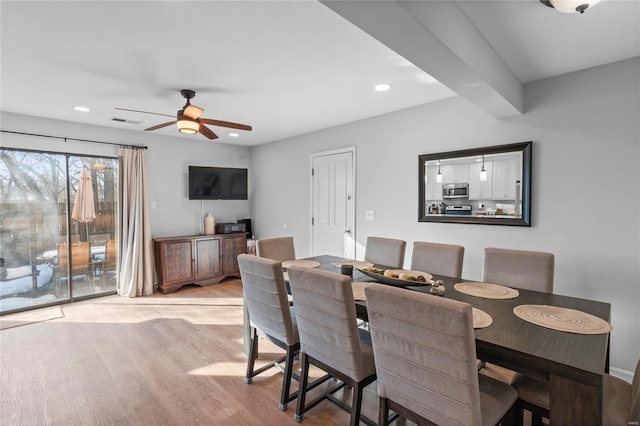 dining space featuring ceiling fan, beam ceiling, and light hardwood / wood-style flooring